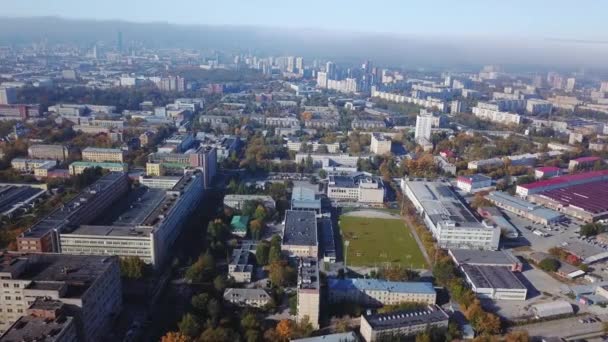 Вид с воздуха на город с футбольным полем в центре. Городской пейзаж . — стоковое видео