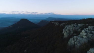 Sabah dağ manzara sis dalgaları ile. Vurdu. Üstten görünüm Dağları sis ve rock alacakaranlıkta. Kayalar ve dağlar dusk dikilen orman örtüsü ile mistik sisli peyzaj.