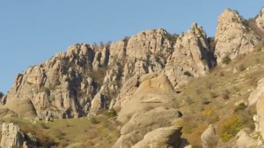 Dağlar tepeler geç sonbaharda üzerinde yeşil küçük ağaçları ile güzel manzara. Vurdu. Güzel, sıradışı kayalar ve solmuş sonbahar günbatımı çalıların