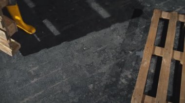 Sarı kauçuk erkek işçi boş ahşap kasalar geceleri yere koyarak botlar. Yakın çekim