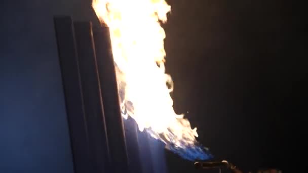 Close-up van het branden van de blauwe metalen gevelbekleding. Donkere achtergrond. — Stockvideo