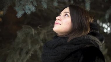 Genç, çekici kız bir kürk manto ve örme eşarp bir kış park, sokak moda arıyorsunuz için kapatın. Kış giysileri çam dalları arka plan üzerinde güzel kadın portresi.