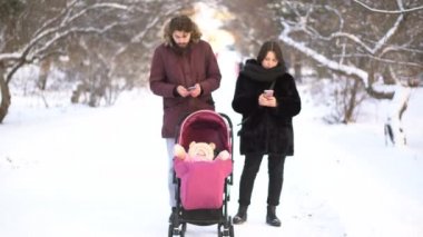Annem ve babam cep telefonları Bebek arabasındaki bebek ve kış parkta yürürken ihmal bağımlısı. Anne Bebek arabası, bağımlılık, değerler kavramı küçük çocuk görmezden akıllı telefonlar ile meşgul.