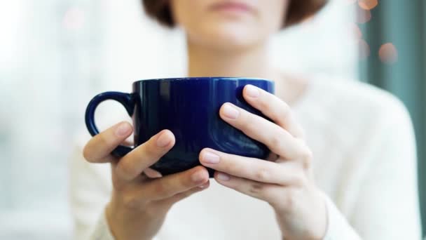 Zbliżenie: niebieską filiżankę kawy lub herbaty w dłoni dziewczyny. Świąteczną atmosferę. — Wideo stockowe