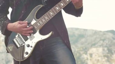 Bas gitar çalmaya adam Close-up. Hisse senedi. Dağlar üzerinde bas artalanda gitarist Close-up