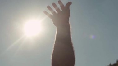 Güneş için ulaşan el Close-up. Hisse senedi. Adam sıcak parlak güneş ışınlarından gökyüzü zevk içinde için uzanıyor. Yüzme yaz güneşte