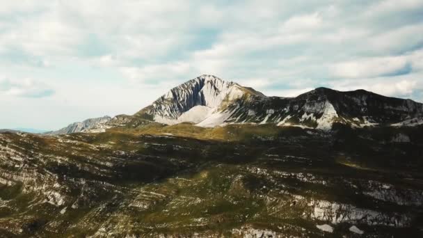 Bovenaanzicht van rotsachtig terrein in het groen met rock. Voorraad. Rock berg erosie. Prachtig uitzicht op de bergen en natuur. Bergpanorama tegen blauwe hemel met wolken — Stockvideo