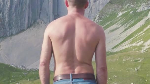 Close-up view of man from back looking at mountain. Stock. Athletic fit man with naked torso his back, looking on beautiful summer mountain landscape. Man fascinated looks at mountains — Stock Video