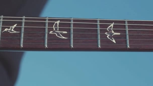 Zblízka - prsty prstoklad struny basová kytara. V UK. Kytarista hraje sólové melodie na akordy na slunečný den — Stock video