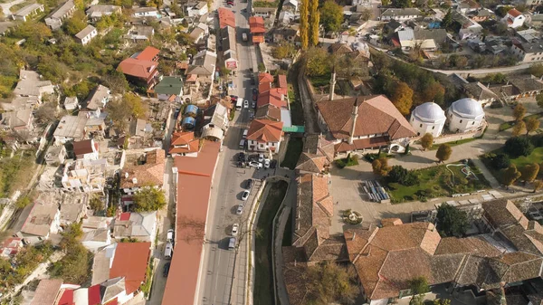 Top view of old city road in summer. Shot. View of asphalt road passing through street with old houses. Old foothill town on sunny day in summer — Stock Photo, Image