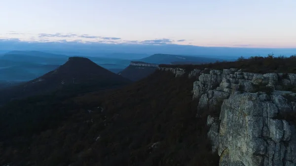 Reggel hegyi táj, a hullámok a köd. Lövés. Szemközti nézet a hegyek a köd és a rock alkonyatkor. Misztikus, ködös táj a sziklák és a hegyek az erdősültség a napnyugtának félhomály — Stock Fotó