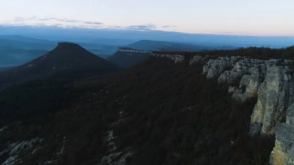 Reggel hegyi táj, a hullámok a köd. Lövés. Szemközti nézet a hegyek a köd és a rock alkonyatkor. Misztikus, ködös táj a sziklák és a hegyek az erdősültség a napnyugtának félhomály — Stock Fotó