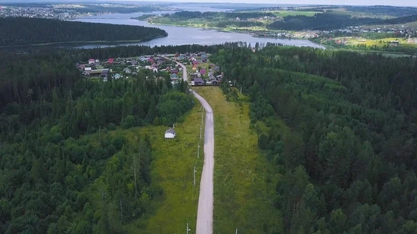 Blick von oben auf Einzelhaus im Wald. Clip. abgelegenes Haus von der Stadt entfernt im Wald in Ruhe und Beschaulichkeit. Hintergrund ist Stadt am Flussufer in Waldgebiet — Stockfoto