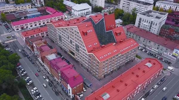 Κάτοψη του κτηρίου με την κόκκινη στέγη. Κλιπ. Συγκρότημα κτιρίων σε ευρωπαϊκό στιλ, με κόκκινες στέγες τριγωνικό και μοντέρνα πρόσοψη. Αστική αρχιτεκτονική — Φωτογραφία Αρχείου
