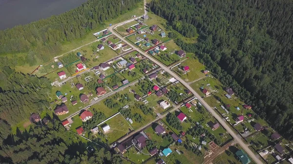 Pohled shora pobřežní města. Klip. Chalupa obec v lesnaté oblasti jako ráj míru a klidu. Panorama z vesnice se nachází na břehu široké řeky — Stock fotografie