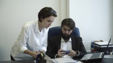 Müdireye ofiste patronu için belgeleri gösteren. Şef onun telefon toplantı sırasında oynuyor.