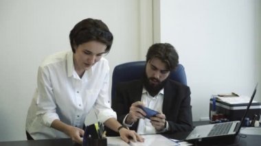 Müdireye ofiste patronu için belgeleri gösteren. Şef onun telefon toplantı sırasında oynuyor.