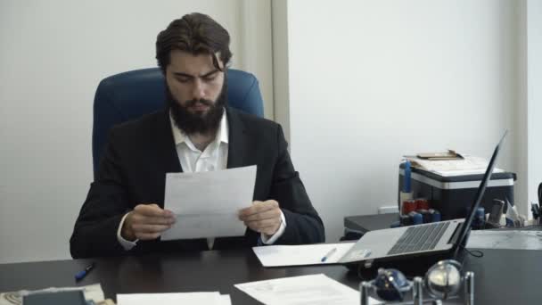 Hombre de negocios confiado mirando a través de papeles y firmar el documento en el escritorio en la oficina moderna. Horario comercial . — Vídeo de stock