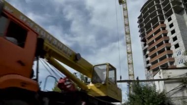 Yüksek katlı Mavi gökyüzü bulutlu karşı bir vinç ile bina inşaatı. Sahne. Alt görünümü. çok katlı bina ile çöp bina ile boş pencere eşiği inşaat sürecinde gri