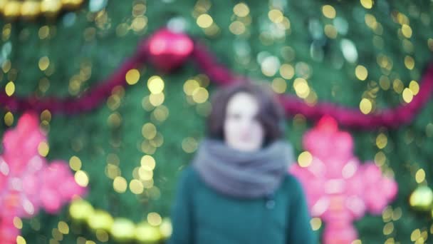 大きなスカーフ笑顔冬 クリスマス明るい背景に屋外で美しい少女 クリスマス ツリーの近くのニット スカーフで笑みを浮かべて少女の屋外冬の肖像 — ストック動画