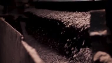 Ezilmiş moloz düşen, ağır maden sanayi işlemini kapatın. Bir fabrikada küçük makadam kırma.