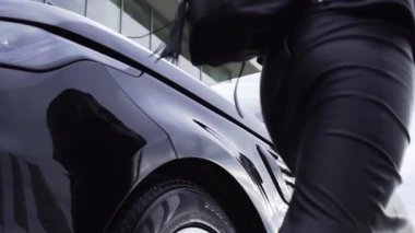 Alt görünümü siyah arabaya gelip giden genç kadının kapıyı aç. Hisse senedi. Siyah küçük sırt çantası gidiş ile gri etek kadında cuv kapıyı açmak için.