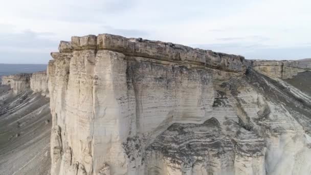 Aérea para maravilloso paisaje de roca blanca con pendiente empinada y un valle con hierba verde. Le dispararon. Caliza blanca con un acantilado vertical sobre fondo azul, cielo nublado . — Vídeos de Stock