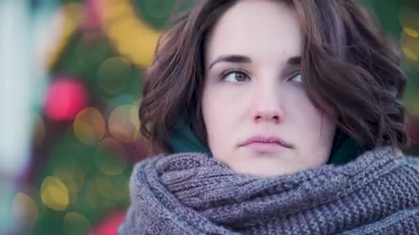 Winter portret van een jong mooi meisje op de straten van een Europese stad. Close-up van de mooie jonge vrouw met sjaal buiten in de winter. Model dragen jas, sjaal — Stockvideo