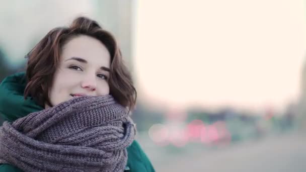 Beautiful cute young woman with a scarf on the street on background city. Urban style — Stock Video