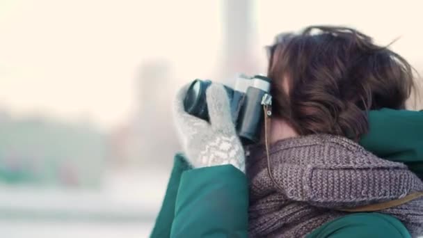 Linda joven mujer tomando fotos. Hermosa mujer joven tomando fotos en la ciudad en invierno — Vídeos de Stock