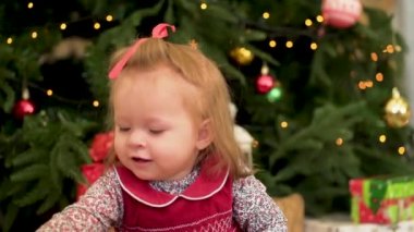 Noel çocuk. Sevimli küçük çocuğun yanında ağaç. Noel çocuklar. Küçük kız Noel ağacı yakınındaki oyuncaklar ile oynama