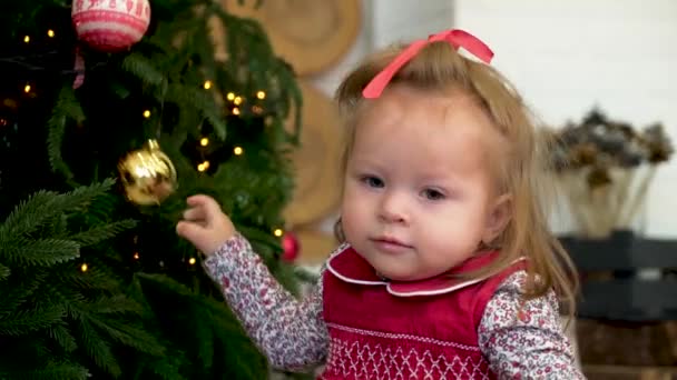 Petite fille décorant le sapin de Noël. Petite fille jouant avec le jouet sur l'arbre de Noël .
