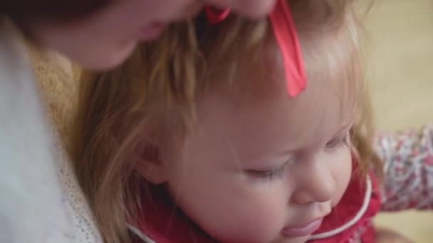 Jovem mãe segurando uma criança com guirlandas em suas mãos. atmosfera de Ano Novo — Vídeo de Stock