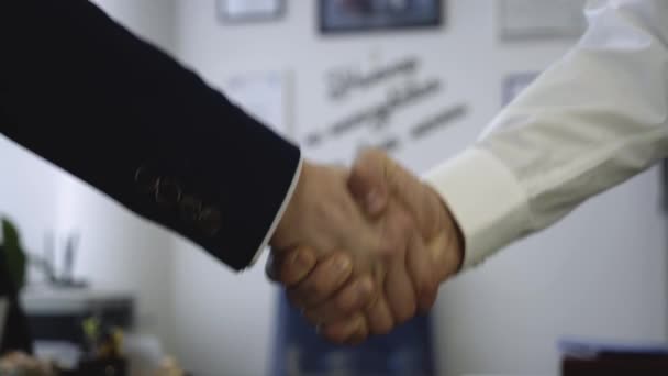 办公室背景上握手的特写镜头。良好的商业交易确保了与握手的合作。两个同事握手过程 — 图库视频影像