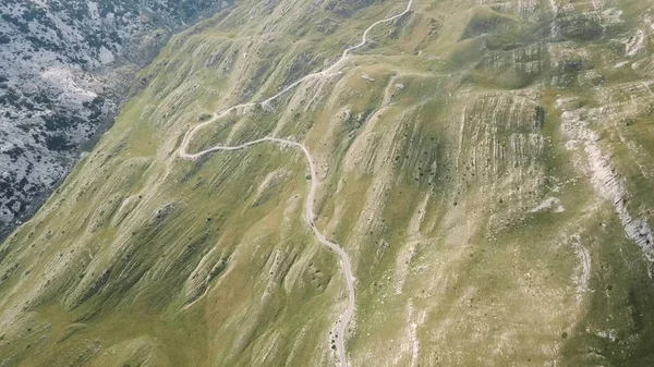 Top view of mountain road. Stock. Dangerous winding roads on mountain slopes. View of road in mountains breathtaking