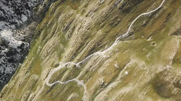 Vista dall'alto della strada di montagna. Azioni. Pericolose strade tortuose sui pendii delle montagne. Vista della strada in montagna mozzafiato — Foto Stock