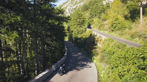 Vue de dessus du trafic routier de montagne. Des actions. Trafic sur piste de montagne en été. Motocycliste va à la rencontre des aventures sur la route serpentine. Été, vacances, voyages et montagnes — Photo