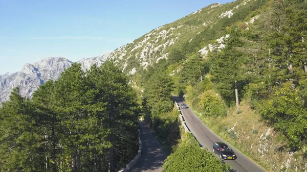 Top view of mountain road traffic. Stock. Traffic on mountain track in summer. Motorcyclist goes to meet adventures on serpentine road. Summer, vacation, travel and mountains