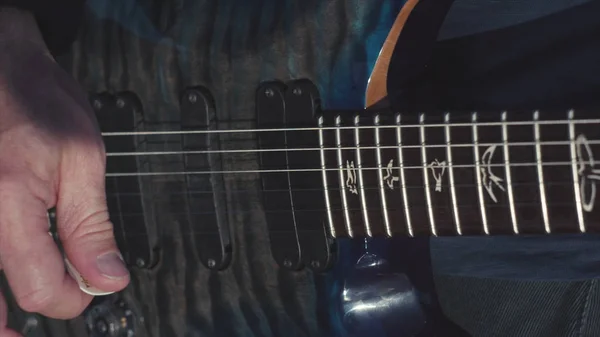 Close-up de mãos tocando baixo. Estoque. Mãos masculinas de guitarrista tocando acordes no baixo. Música executada na guitarra — Fotografia de Stock