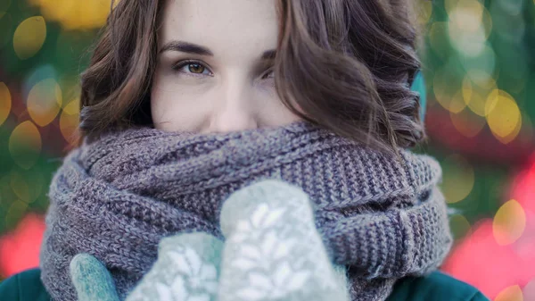Winterporträt eines jungen schönen Mädchens auf den Straßen einer europäischen Stadt. Nahaufnahme einer schönen jungen Frau mit Schal draußen im Winter. Modell trägt Mantel, Schal — Stockfoto