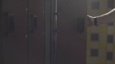 El bileği soyunma odası spor salonunda elektrik anahtar ile soyunma açılış mans. Çerçeve. Spor salonu soyunma odasında Dolap Kapı açma el kadar kapatın.