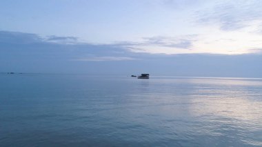 Deniz su ve güzel mavi bulutlu gökyüzü dışında gelen küçük taşlarla. Vurdu. Huzurlu günbatımı romantik atmosferde denizde.