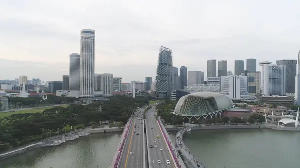 Singapour - 25 septembre 2018 : Aérien pour Singapour avec de nombreuses voitures sur le pont au-dessus du lac et des bâtiments de la ville. Fusillade. Ville de Singapour skyline avec pont et bâtiments modernes . — Photo