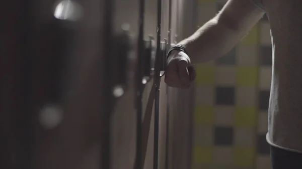 Casier d'ouverture de main de Mans avec clé électrique sur son poignet à la salle de gym dans le vestiaire. Cadre. Fermez la main en ouvrant la porte du vestiaire dans le vestiaire d'une salle de gym . — Photo