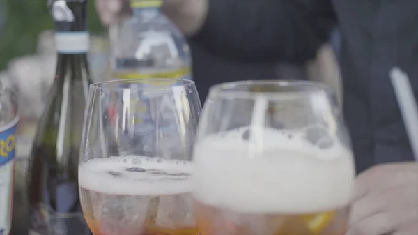 Sluit voor twee MMMMMMMMMMM glazen met ijsblokjes en bubbels op feestelijke tafel. Frame. Glazen sprankelende MMMMMMMMMMM wijn op de tafel van een feestzaal. — Stockfoto