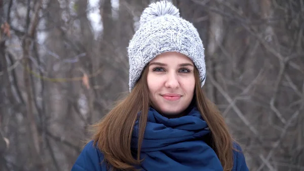 Szczegół portret pięknej młodej kobiety kaukaski uśmiechający się w zimie Kurtka, czapka i szalik. Brunetka dziewczyna snowy drewna portret. — Zdjęcie stockowe