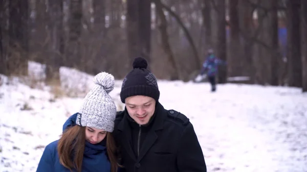 Genç çift, sarılma ve kışın parkta öpüşme. Kış soğuk günlerde kış elbiseleri giymiş güzel bir çift portresi. Genç çift romantik bir an zevk — Stok fotoğraf
