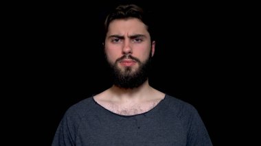 Kızgın genç adam sakallı işaret onun kafa, izole üzerinde siyah arka plan sallayarak katılmıyorum yapar. Mutsuz ve kızgın ret gösteren izole arka plan üzerinde gri kazak giyen yakışıklı adam