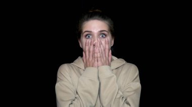 Sürpriz güzel kadın tarafından siyah arka plan üzerine izole ellerini, yanakları tutar. Genç kadın şok