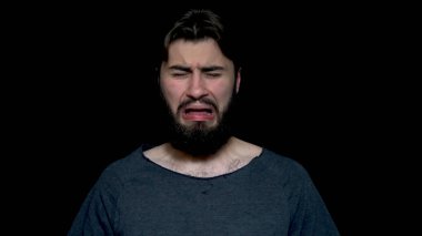 Genç adam bir şey onun koltukaltı koklama kokuyor çok kötü, siyah arka plan üzerine izole sakallı. Olumsuz duygu, Genç adamın onun kokuşmuş koltuk altı, hoş olmayan bir koku kokulu yüz ifadesi